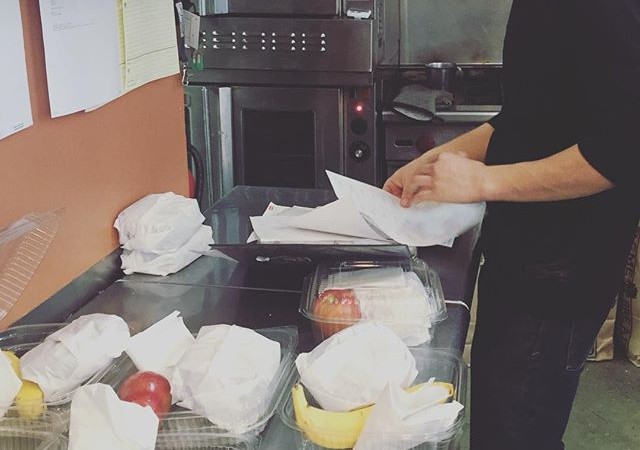 Behind the Scenes at Yali's Cafe: Hard work at Yali's doesn't mean a lack of fun! Ray, one of our amazing cooks, smiles as he puts together some lunch boxes for a catering order. Looking to order something for an event or meeting? Go to yaliscafe.com for our menu and online ordering form!